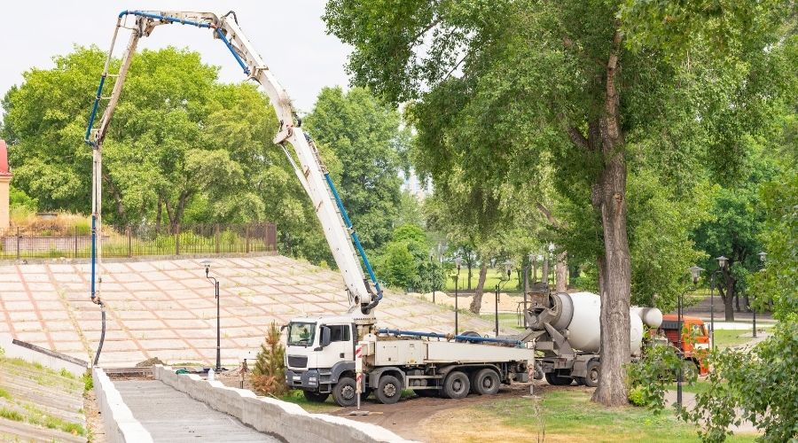 Kamion pompë betoni me krah të zgjatur kundër një qielli dramatik